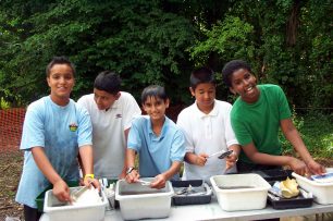 Children from Bushfield School washing finds from the archaeological dig in the Secret Garden