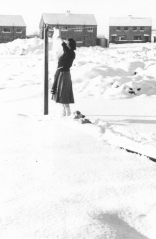 Vera Barrow pegging out washing during her first winter in Bletchley