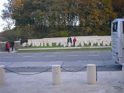 Colour photograph showing a view of headstones from across the road at the Ploegsteert Memorial to the Missing at the Royal Berkshire Cemetery Extension.