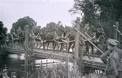 Slide of horse team and gun carriage on a bridge.