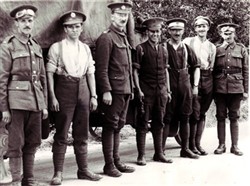 Photograph of seven soldiers stood in a line.