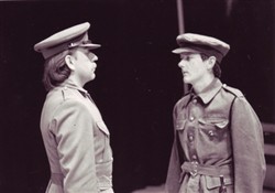 Photograph of two people dressed as soldiers talking to each other.