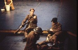 Slide of three soldiers inspecting their kit