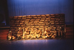 Slide of eight soldiers sat on the floor by a wall