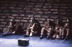 Slide of soldiers sat against a wall.