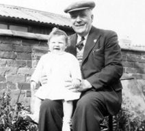Photograph of elderly man holding a baby