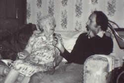 Slide of an elderly woman sat next to a man on a settee
