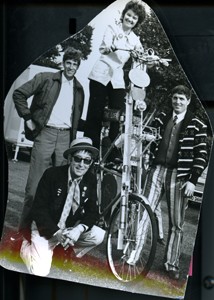 Bernice Edwards on a tall bicycle with three men at the Carnival.