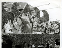 A carnival float of women dressed as butterflies.