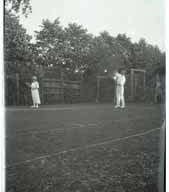 Negative of two people playing Tennis.