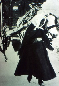 Slide of a woman leading a horse and cart