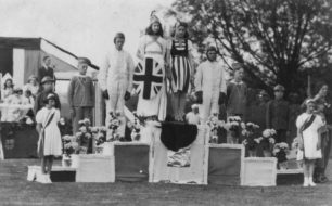 Photograph of eight youths on a podium in fancy dress.