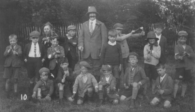 The Poachers group. A group of boys with catapults (and a moustachioed man).