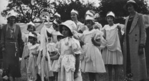 Group of ten girls dressed up (one as Bo Peep maybe) with two women