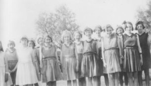 Group of 14 girls with matching dresses.