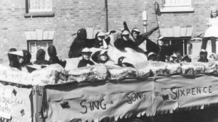 Parade float titled "Sing a Song of Sixpence" with a group of children dressed up as blackbirds .