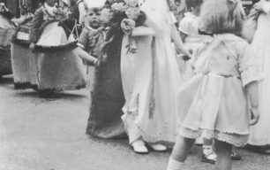 Carnival Procession with a young carnival queen and reluctant pageboy in a street