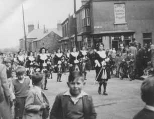 The Dagenham Girl Pipers lead a parade round New Bradwell