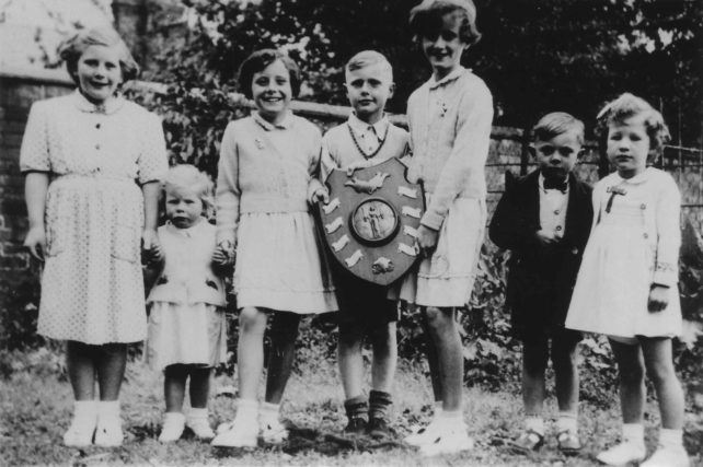 Young Wood Street residents with the trophy for best decorated street on the occasion of the 1953 Coronation