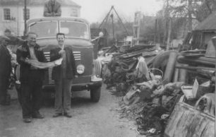 Goodmans Yard. Bernard Goodman on a lorry, Derek & John in front, with a fish. Johnny on left