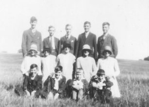 Group of five men, five women and four boys in a field.