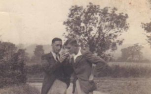 Two young men lighting cigarettes