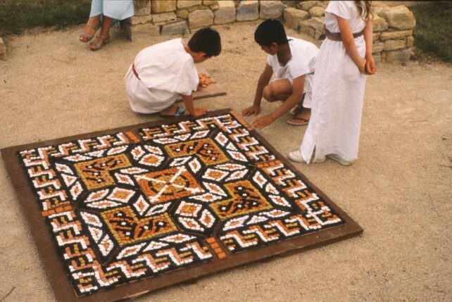 Children finishing clay mosaic