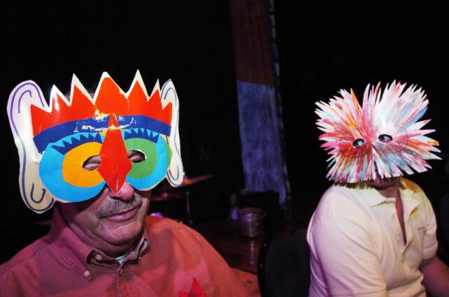 Two figures wearing colourful face masks
