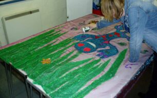 Pouring glitter on a Groovy Gecko banner