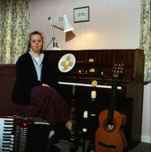 Lady sitting in front of musical instruments
