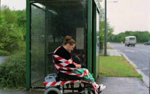 Lady in wheelchair wrapped in red and white tape