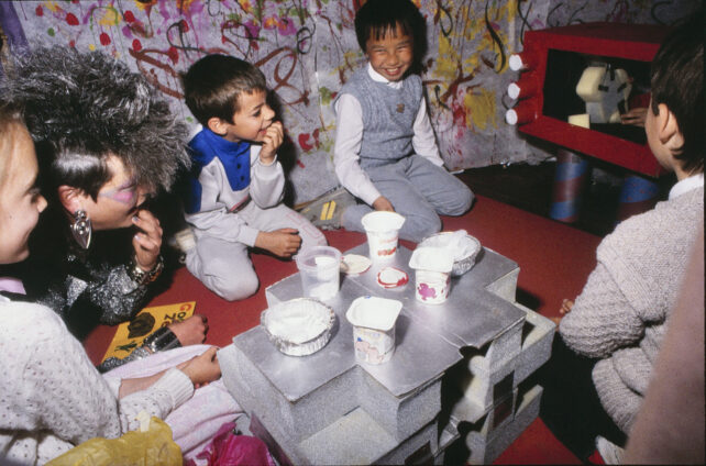 The children and Zerena watch TV in Zerena’s home