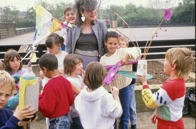 Outside in the playground, a group of children gather with Zerena getting ready for the goodbye parade