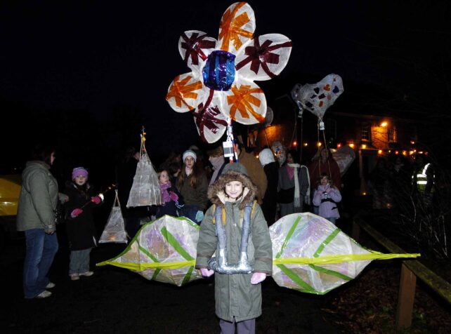 Child with lantern of flower and leaves