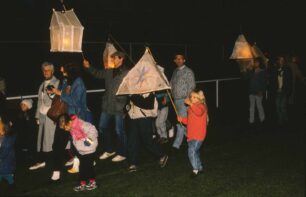 Adults and children walking with lanterns