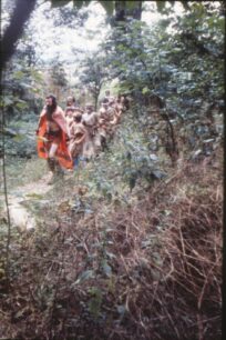 The tribe being led on an expedition in the woods