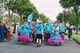 Samba group dressed in blue and pink costumes.