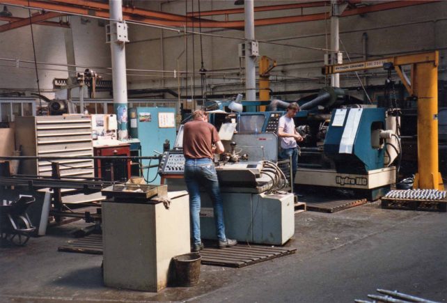 Two men at Middle Bay Auto lathes in Fitting Shop
