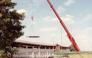 The crane lifting steel girders over the footbridge & into the car park