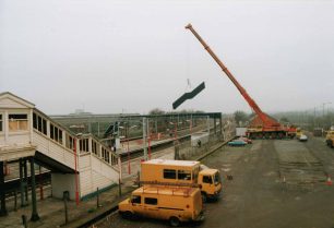 Crane lifts station footbridge staircase above the overhead cables