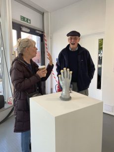 Artist Jill Kitchen explains the silver hand to member of public