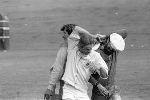 Three entangled men in a Frisbee competition