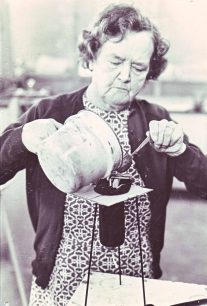 A woman pouring liquid into a mould