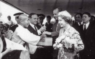 The Queen receiving a gift from a Buddhist monk