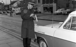 Mr Fuller, traffic warden, delivers a parking ticket, Queensway, undated
