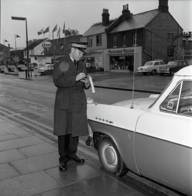 Mr Fuller, traffic warden, delivers a parking ticket, Queensway, undated
