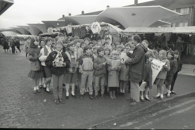 Knowles School pupils carol singing by the market, 16 December 1986