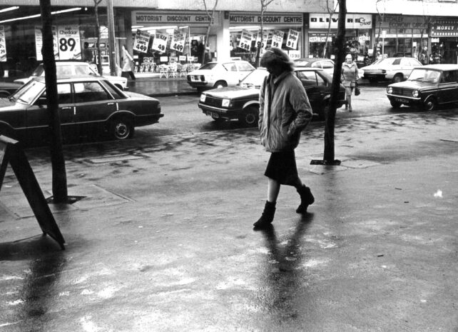 Pedestrian on rainy Queensway, December 1982