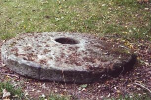A mill runner stone set on turf