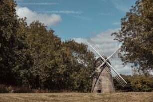 2 images of the windmill framed by trees